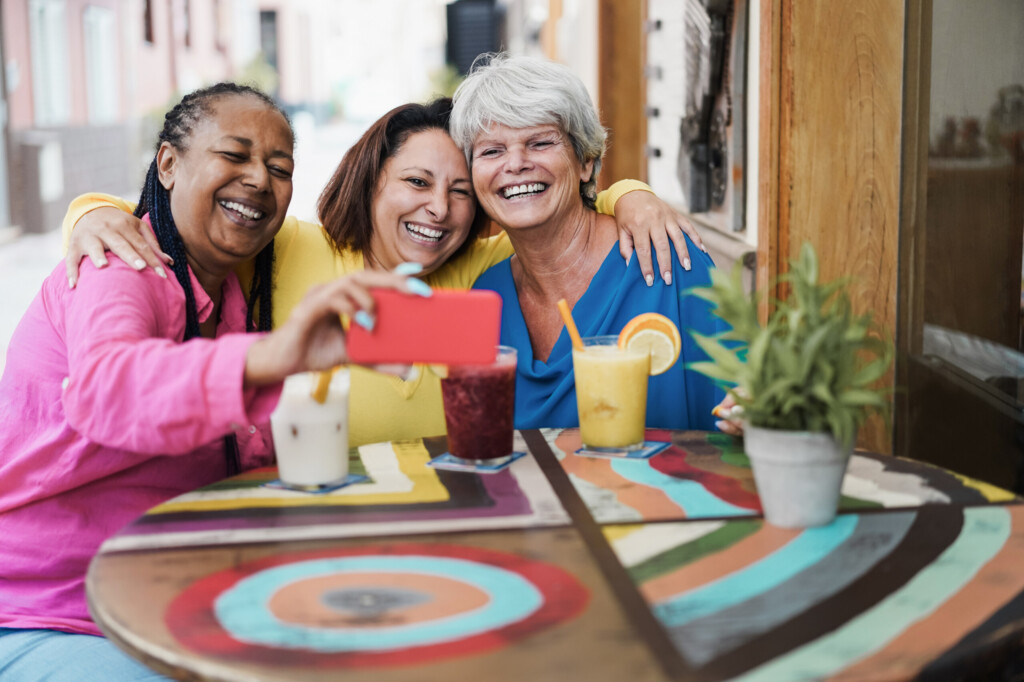 Smiling senior woman using her phone, representing independence, connection, and quality of life.